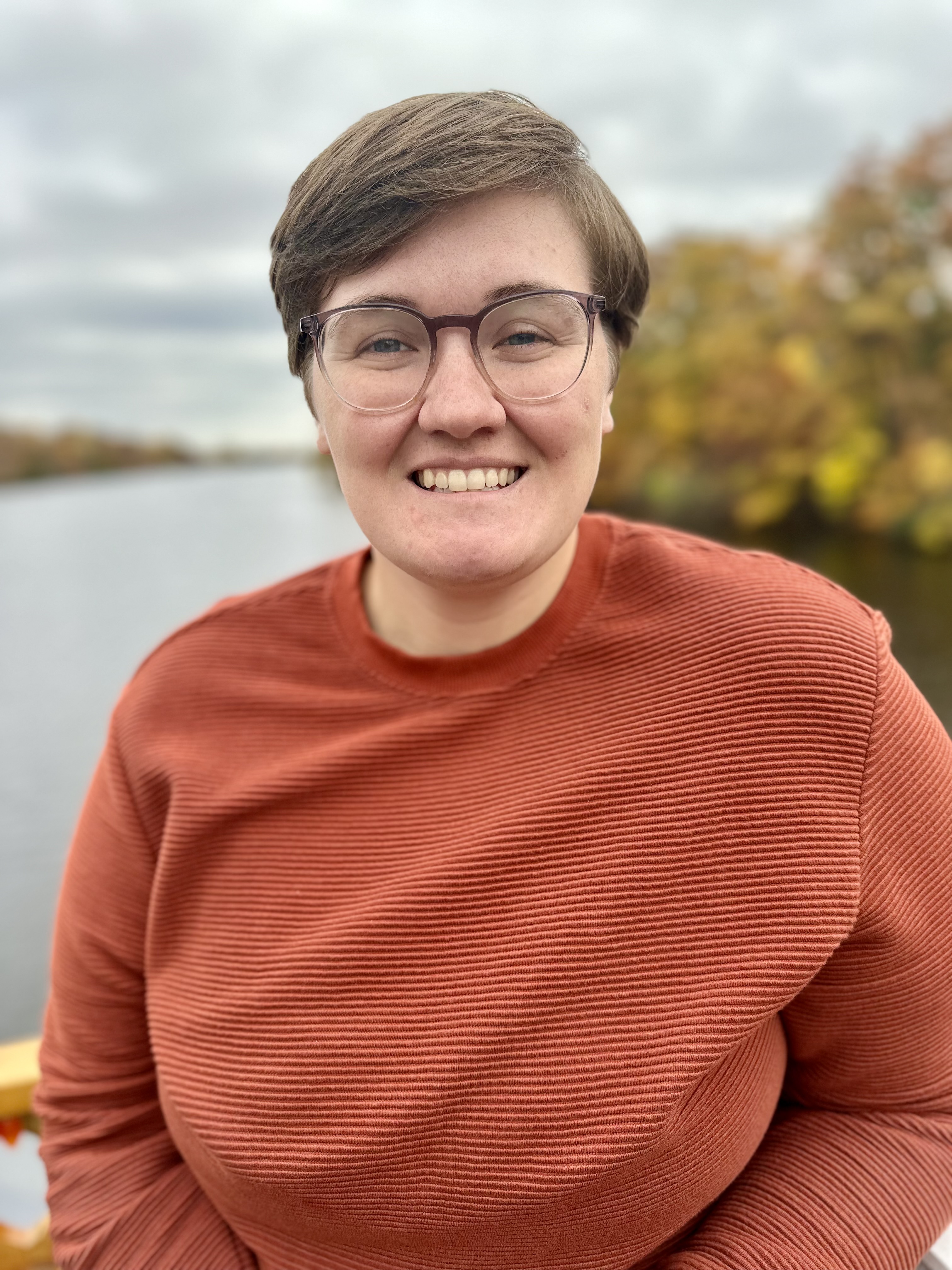 Laurisa Ankley, founder of GradPhinDer, standing outside near a lake